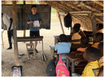 a class of young children watches a teacher in front of class